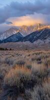 Sunset glow over jagged mountains in serene landscape photo