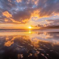 Sunset at the beach with clouds reflecting in the water photo
