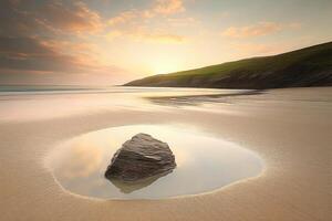 Golden sunlight illuminating a tranquil beach with a rock photo