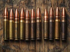 Collection of bullets arranged on a wooden surface photo