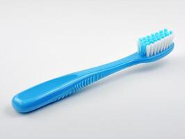 Simple blue toothbrush with soft bristles placed on a white background photo