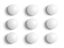 Arrangement of nine white spheres on a clean surface photo