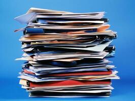 Piled documents and papers on a blue background in an office space photo