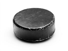 Black hockey puck on a light background ready for a game photo