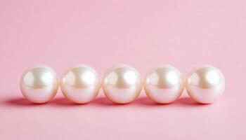 Elegant pearls arranged on a soft pink background photo
