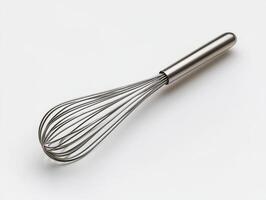 Stainless steel whisk placed on a plain surface photo