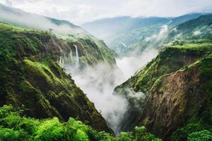 Lush green valleys shrouded in mist reveal cascading waterfalls photo