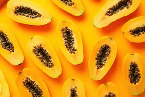 Fresh papaya halves arranged on a vibrant orange background photo