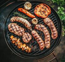 Grilling sausages, steak, and vegetables over hot coals photo