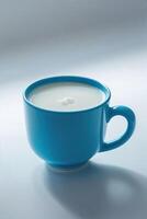Cup filled with fresh milk on a light surface during daytime photo