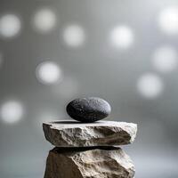 Elegant arrangement of a smooth black stone balanced on textured beige rocks with a soft bokeh background photo