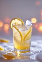 Refreshing lemonade drink garnished with lemon slices and ice cubes on a table with soft glowing background lights photo