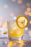 Refreshing lemon drink served with ice in a clear glass with a soft bokeh background photo