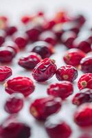 Dried red cranberries scattered on a countertop creating an attractive texture and color display photo