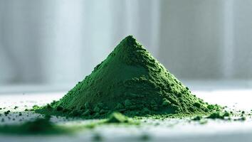 Green powder pile on a white surface with soft light showcasing texture and color photo