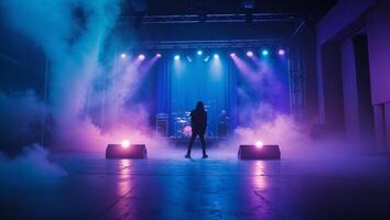 Musician prepares for performance on stage amidst colorful lights and fog photo