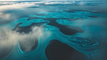 Swirling turquoise patterns on a serene water surface under a cloudy sky during daytime photo