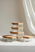 Stylish storage containers stacked neatly on a countertop featuring wooden lids in a bright, minimalistic kitchen setting photo