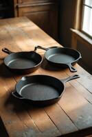 Rustic kitchen setting with cast iron skillets on a wooden table in warm sunlight during the afternoon photo