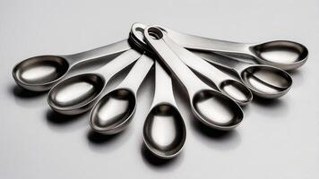 Stainless steel measuring spoons arranged creatively on a light background for kitchen use and culinary preparation photo