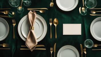 Elegant table setting for a formal dinner event featuring gold utensils and fine china on a dark green tablecloth photo