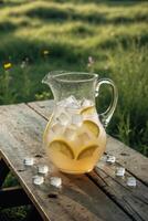 Refreshing pitcher filled with lemonade and ice cubes on rustic wooden table in vibrant green meadow photo