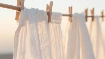 White fabric hanging on a clothesline at sunset creating a peaceful and serene atmosphere photo