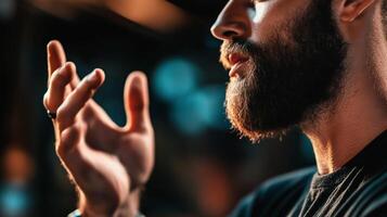 Man with beard gestures expressively in a dimly lit environment during an evening gathering photo