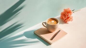 Coffee with latte art, a notebook, and a flower create a serene workspace during an afternoon break photo