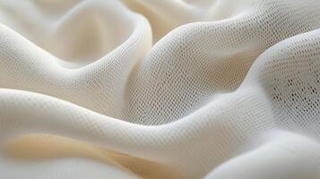 Soft textured fabric in gentle waves showcasing intricate patterns and a creamy color in a bright indoor setting photo
