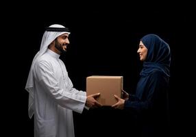 Arab Couple Exchanging Package Delivery Black Background photo