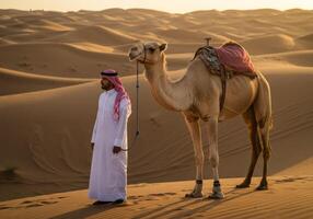 Walking with a Camel in the Desert Landscape at Sunset Time photo