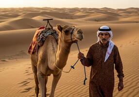 A Saudi Gulf Arab man standing next to a camel in the desert photo