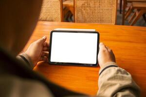 Hands holding a tablet with an empty white screen, perfect for digital design or app presentation. photo