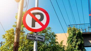 March 8, 2025, Semarang, Indonesia, a no parking sign is installed on the road with a clear sky in the background. photo