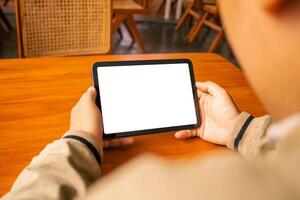 Man using a tablet with a blank screen, placed on a wooden table with a stylus, great for design photo