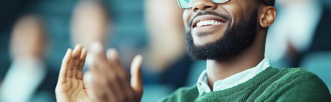Joyful man clapping in bright office, showcasing enthusiasm and positivity. His smile reflects supportive atmosphere among colleagues photo