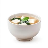 bowl of hot miso soup with tofu and seaweed, garnished with fresh herbs, offers comforting and nutritious meal. Perfect for warming up on chilly day photo