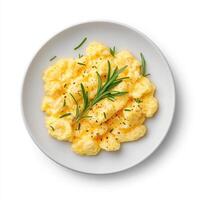 Fluffy scrambled eggs garnished with fresh herbs, perfect for breakfast. creamy texture and vibrant colors make this dish appealing and delicious photo