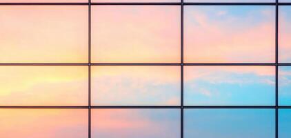close up of high rise glass facade reflecting colorful sunset sky, showcasing vibrant hues of pink and blue. modern architecture creates stunning visual effect photo