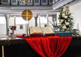 Catholic Church in Germany, altar with flowers, candles and an open bible, confirmation day. photo