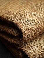 Brown burlap fabric folds, closeup, neutral background, texture or packaging use photo
