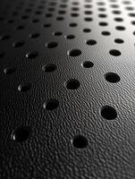Black surface with holes, repetitive pattern, close-up, for industrial use photo