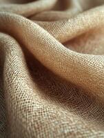 Tan fabric drapes with texture. Background is blurred. Use in textiles photo