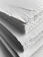 Stack of textured white paper, edges frayed, in a high-angle view photo