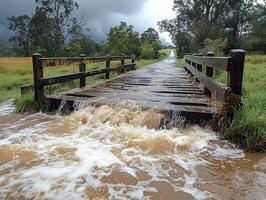 Rural wooden bridge flooding during storm, overflowing creek photo
