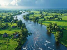 Aerial River Flowing Through Green Farmland Under Cloudy Sky photo
