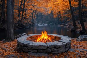 Campfire burning in stone pit by river surrounded by fall foliage, for camping or travel photo
