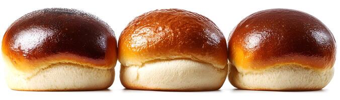 Three golden brown bakery buns in a row photo