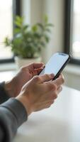 Close up of hands using smartphone with blank screen in office environment photo